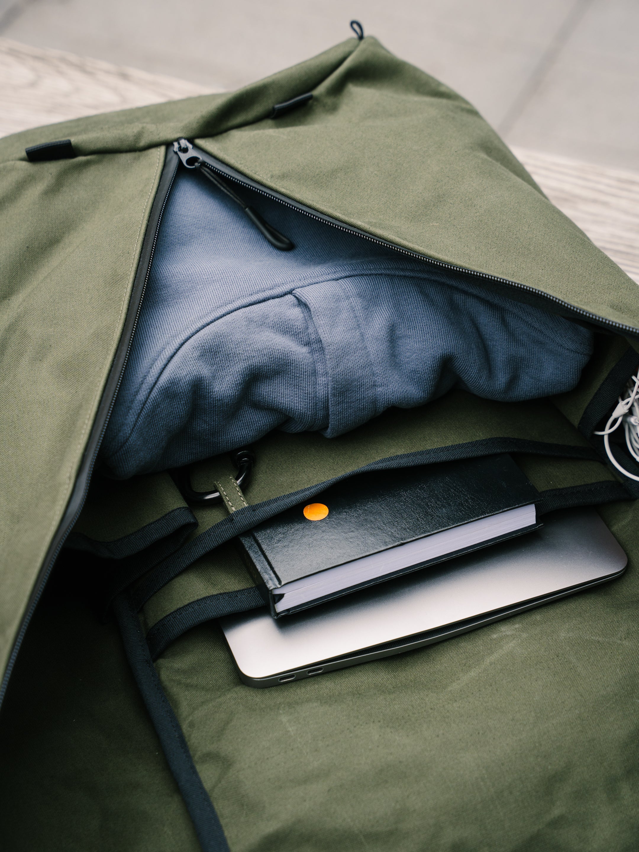 Interior of the Bridge Backpack in Khaki Green showing laptop sleeve, notebook and clothing organisation