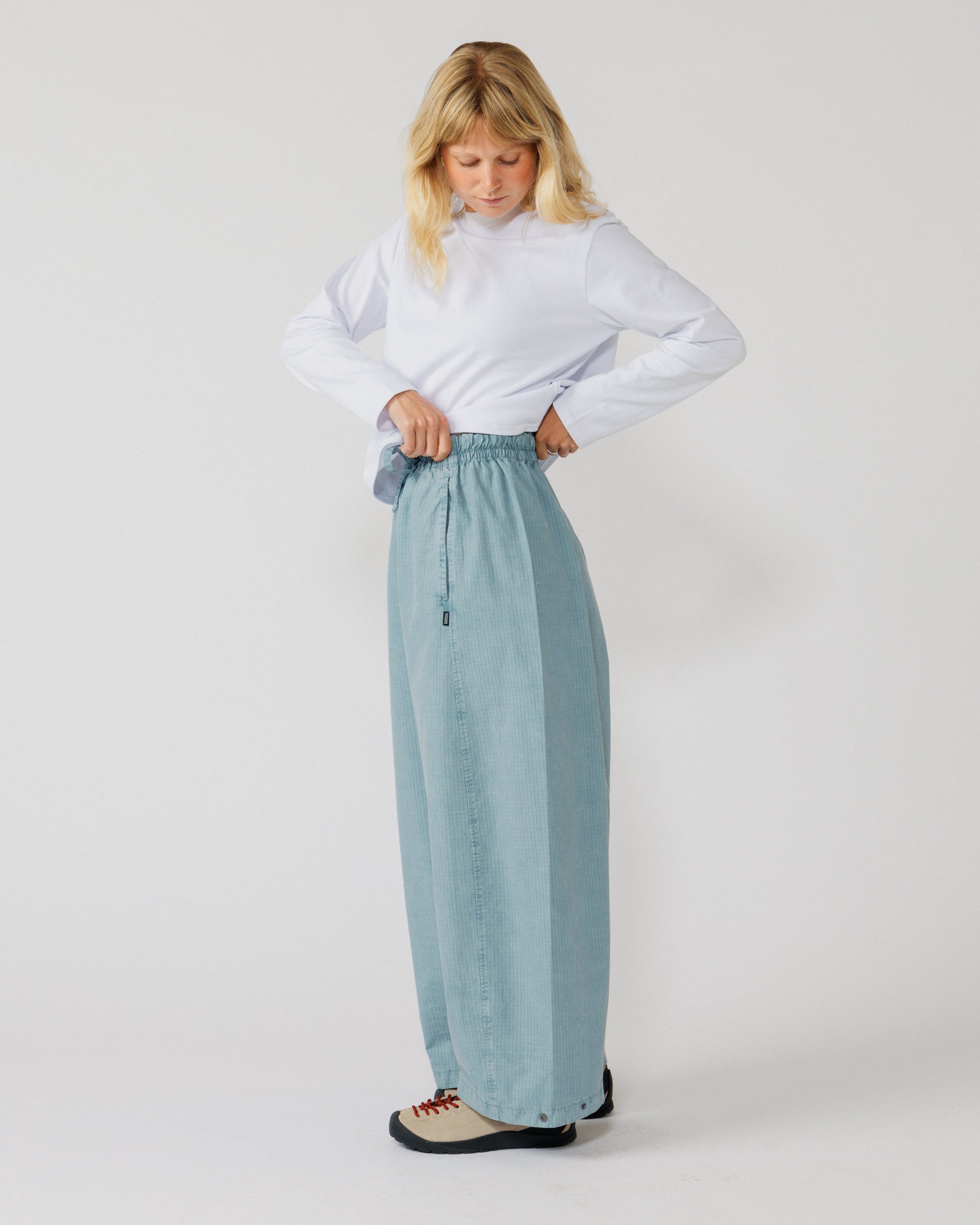 Garment Dyed Atlas Pants - Powder Blue — action shot, elastic waist shown