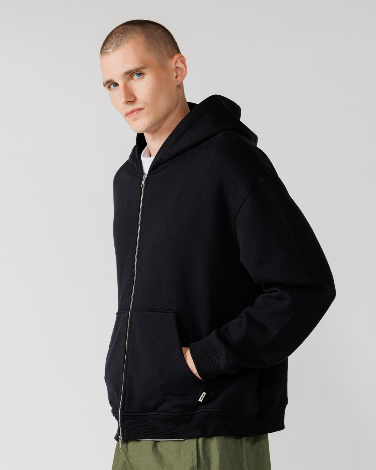 Heavyweight Two-Way Zip Hoody - Black — Male side angle, pocket in use