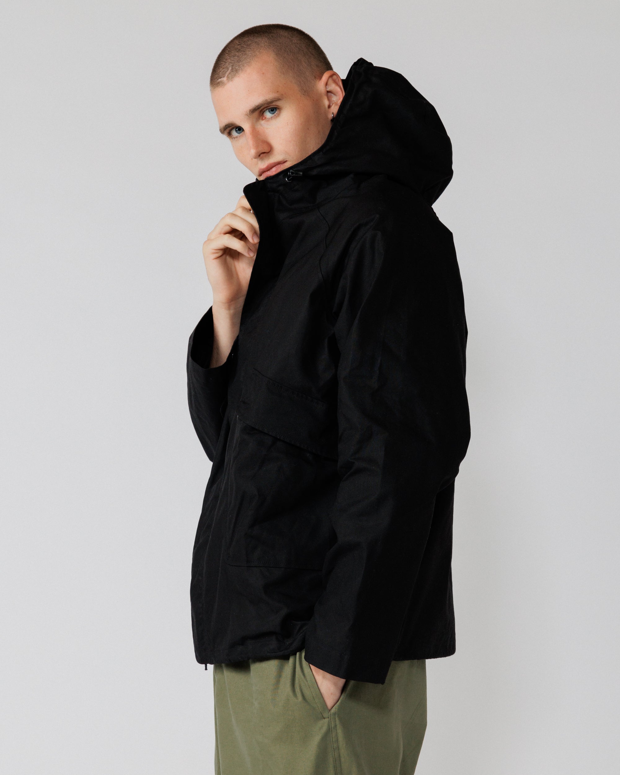 Roam Raglan Jacket - Black — hood up, clean side profile