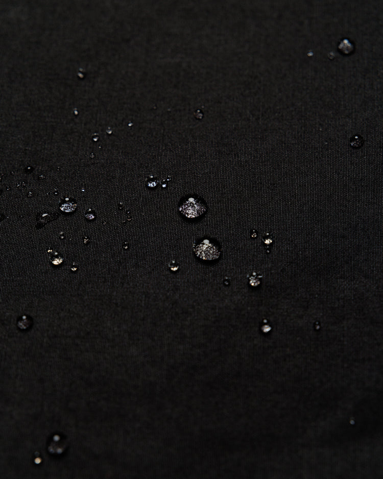 Roam Raglan Jacket - Black — water beading proves weatherproofing
