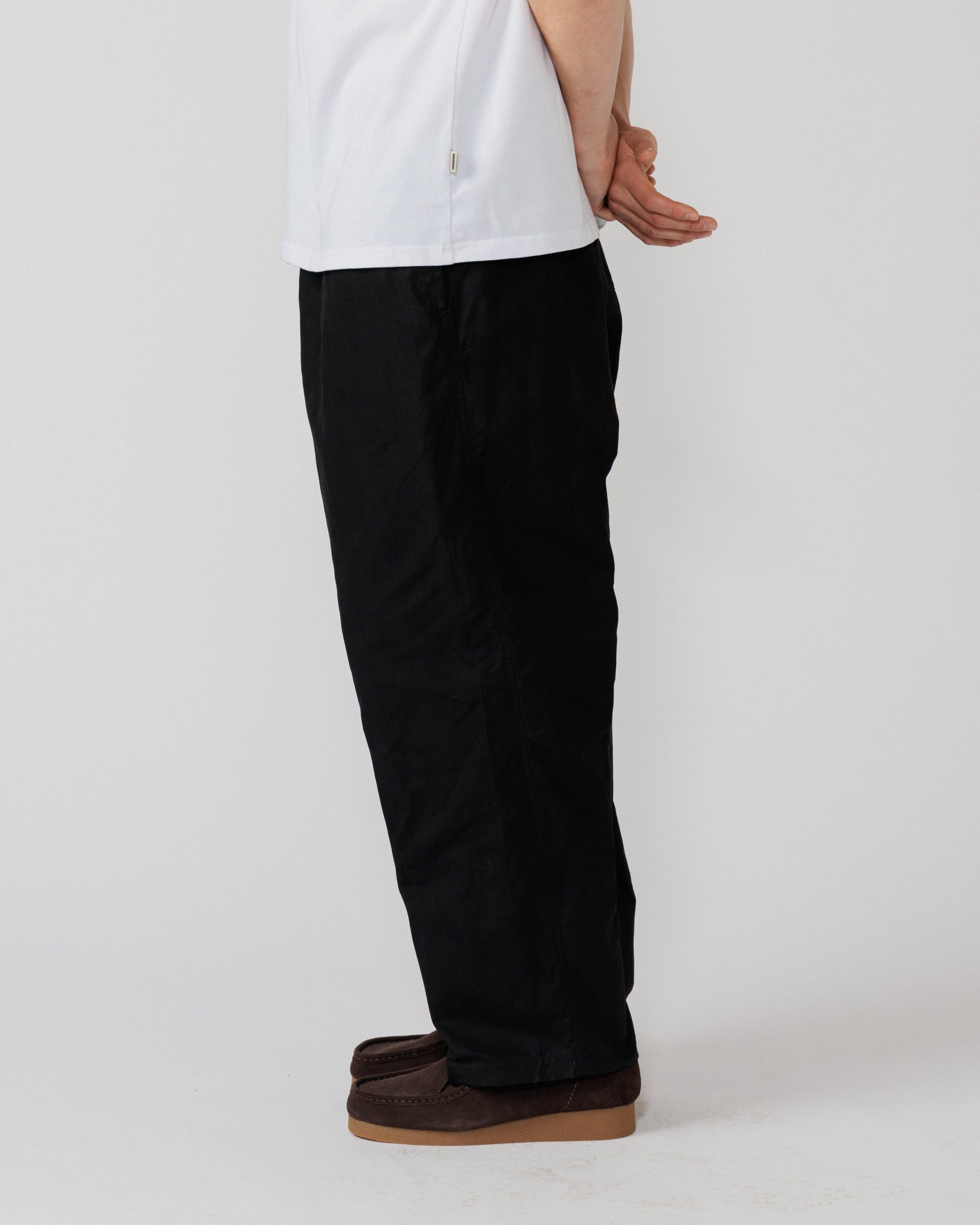 Water Resistant Zama Pants - Black — rear-quarter view leg drape